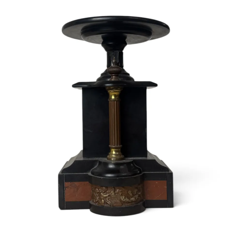 Patera na postumencie z czarnego kamienia z kolumienką i fryzem z puttami, element garnituru kominkowego.