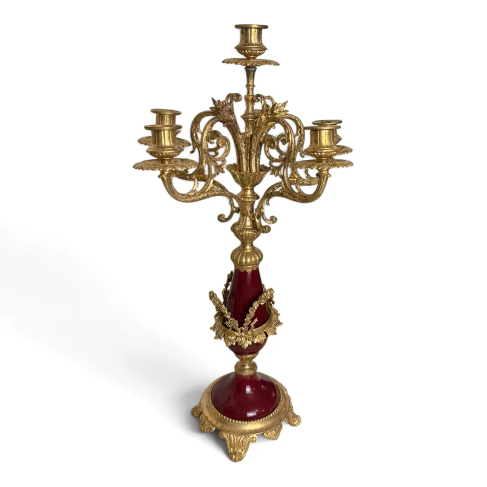 Kandelabr pięcioświecowy z metalu złoconego, z trzonem z bordowej porcelany i ażurowymi ramionami, nawiązujący do stylu Ludwika XVI.